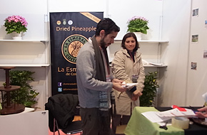 Participants from Costa Rica carry out preparations at a booth that displays dried pineapple.