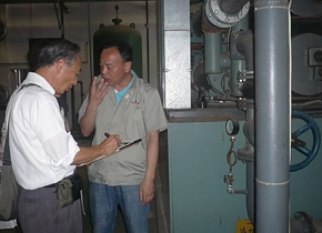 Experts conducts a diagnosis on energy savings while making verifications with an equipment manager, right.