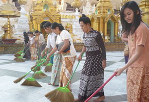 A pagoda is cleaned by a group of female volunteers in a labor-intensive arrangement