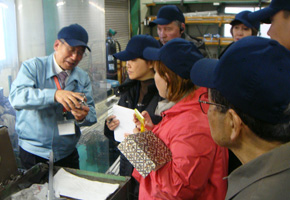 The seminar participants have a field trip inside the factory, as they listen to an explanation on manufacturing processes.