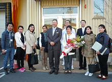 The group, including the company president, take a commemorative photograph.