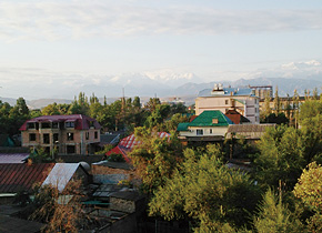 The Ala-Too mountain range can always be seen from the capital Bishkek.  Large wind turbines jut from a wide plain.