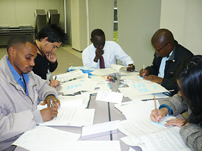 Mr. Sissoko, center, organizes some of the materials he learned at his seminar, along with other participants.